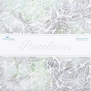 May include: A stack of fabric squares with a floral pattern in shades of gray, white, and green. The fabric is labeled "Porcelains" with the Riley Blake Designs logo. The floral design is a repeating pattern.