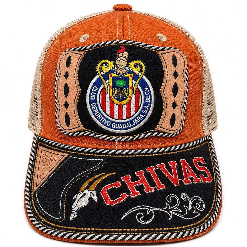 May include: An orange and tan mesh trucker hat featuring a prominent Club Deportivo Guadalajara crest on the front panel. The black brim displays the word CHIVAS in red letters, a white goat skull graphic, and decorative tan leather-like accents.