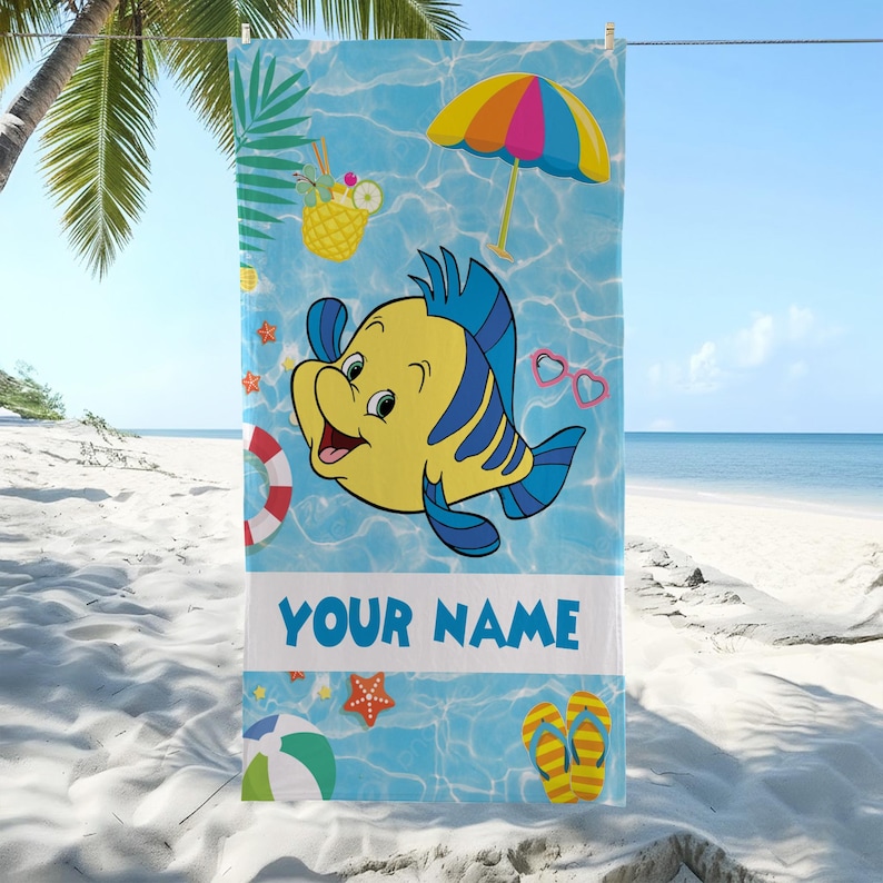Puede incluir: Una toalla de playa rectangular con fondo de agua azul claro, un pez de dibujos animados amarillo y azul, una sombrilla colorida, una bebida de pi&ntilde;a, un salvavidas, gafas de sol, una pelota de playa, chanclas y el texto YOUR NAME.