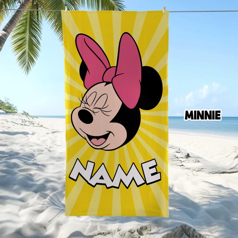 Puede incluir: Una toalla de playa rectangular con un fondo de rayos de sol amarillos y un gr&aacute;fico de Minnie Mouse con un gran lazo rosa. El personaje sonr&iacute;e con los ojos cerrados. La palabra MINNIE est&aacute; impresa en blanco y la palabra NAME est&aacute; en blanco.
