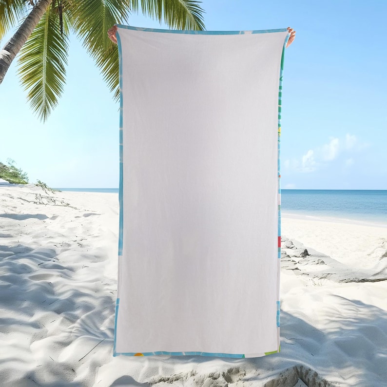 Op de afbeelding: Een grote witte strandhanddoek met een blauwe rand en kleurrijke accenten. De handdoek wordt getoond tegen een strandachtergrond met palmbomen, zand en oceaan. De handdoek is rechthoekig.