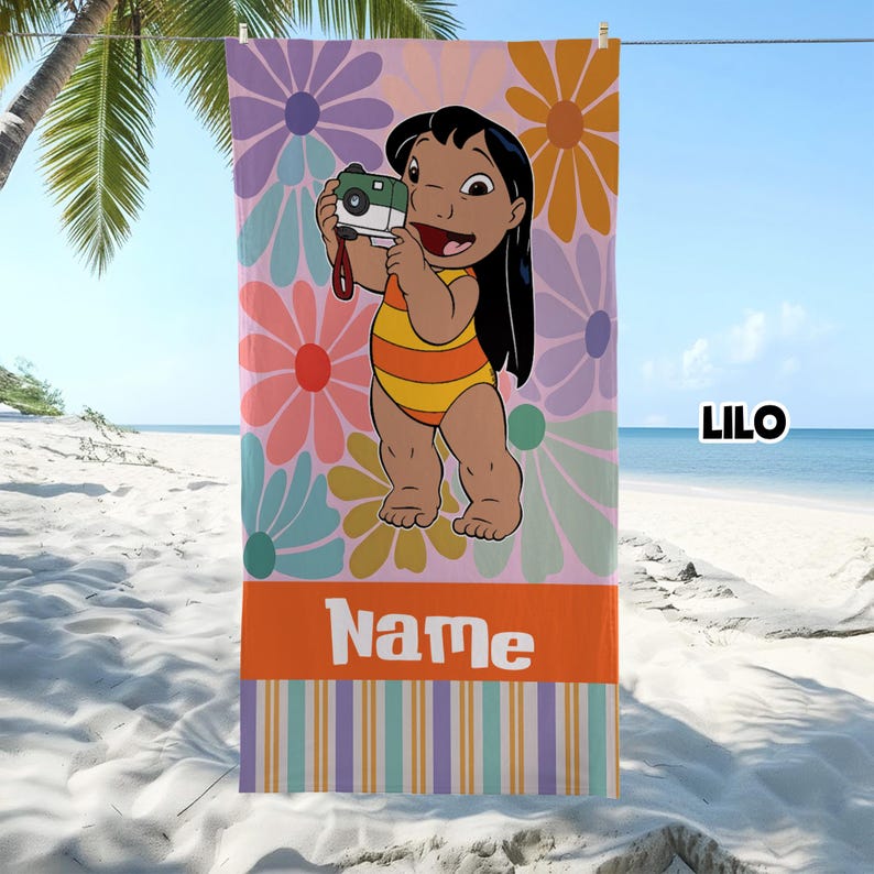 May include: Beach towel featuring a cartoon character holding a camera, set against a floral background. The towel has a pink base with large flowers in various colors. The bottom section is orange with the word "Name" in white.