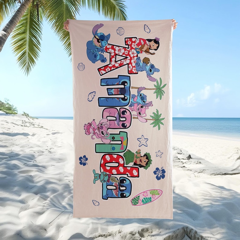 K&ouml;nnte beinhalten: Ein beiges Strandtuch mit dem Namen "Amara" in gro&szlig;en, bunten Buchstaben und Zeichentrickfiguren. Das Handtuch zeigt Bilder von Stitch, Lilo und tropischen Elementen wie Palmen und einem Surfbrett. Der Hintergrund zeigt eine Strandszene.