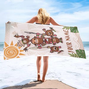 May include: A beach towel featuring a cartoon design of coconut characters with spears and tribal elements. The towel is beige with a sun graphic and the words "YOUR NAME" in a script font. Green monstera leaves are also featured.