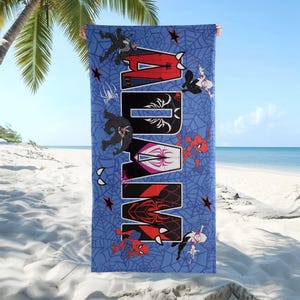 May include: Blue beach towel featuring the name "ADAM" in large, stylized letters with Spider-Man characters and spider web designs. The towel is held up on a sunny beach with palm trees and the ocean in the background.