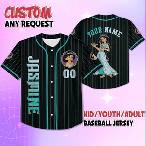 K&ouml;nnte beinhalten: Schwarzes Baseball-Trikot mit t&uuml;rkisfarbenen Nadelstreifen und Akzenten. Es zeigt ein Cartoon-Bild von Prinzessin Jasmin, den Namen "Jasmine" vertikal auf der Vorderseite und den Text "CUSTOM ANY REQUEST". Auf der R&uuml;ckseite steht "YOUR NAME" und ein weiteres Jasmin-Bild.
