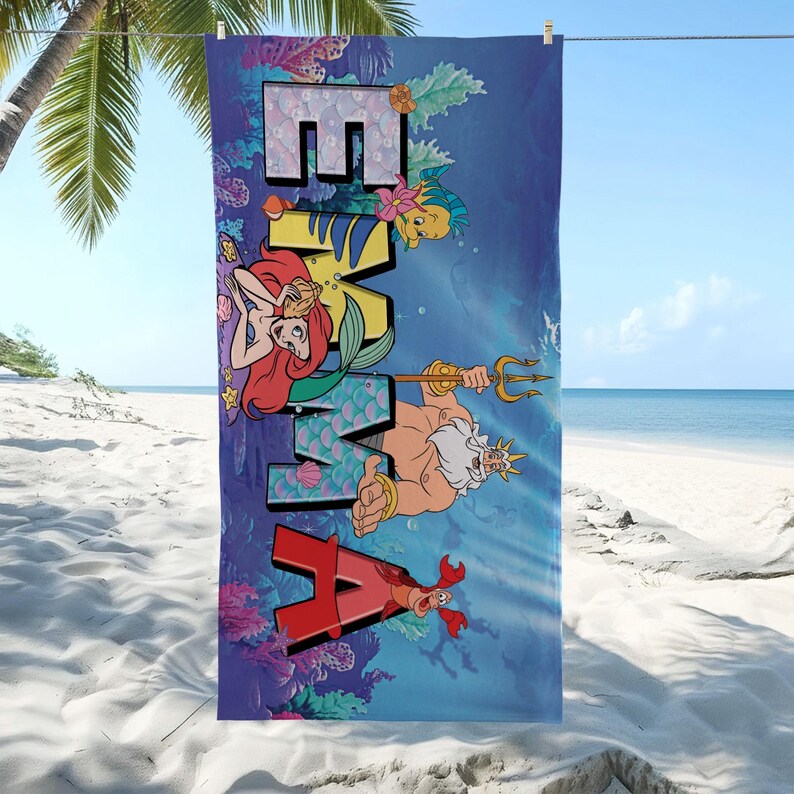 K&ouml;nnte beinhalten: Ein rechteckiges Strandtuch mit einer tiefblauen Unterwasserszene und dem Namen EMMA in gro&szlig;en Blockbuchstaben. Das Design zeigt Zeichentrickfiguren wie eine Meerjungfrau, einen K&ouml;nig mit Dreizack, einen Krebs und einen kleinen gelben Fisch.