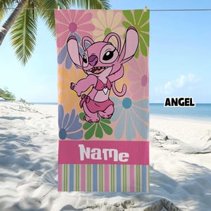 May include: Pink beach towel featuring a cartoon character in a swimsuit, set against a floral background. The towel has a pink stripe at the bottom with the word "Name" in white, and the word "ANGEL" in the top right corner.