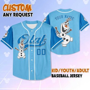 May include: Pale blue baseball jersey with white detailing, displaying the name "Olaf" and the number "00". The jersey features a cartoon image of Olaf on the front and back, with the text "CUSTOM ANY REQUEST" at the top. Available in kid, youth, and adult sizes.