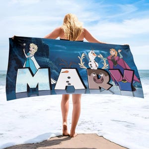 May include: A rectangular beach towel featuring a dark blue background with the name MARY in large block letters. The letters incorporate characters from the movie Frozen, including Elsa, Olaf, and Anna, along with a reindeer face on the letter R.