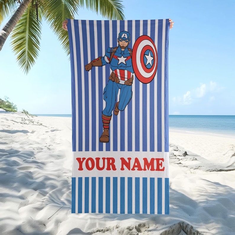 以下が含まれることがあります： キャプテン・アメリカのグラフィックが描かれた、青と白のストライプのビーチタオル。スーパーヒーローは、彼のクラシックなコスチュームで、彼のシールドを持っています。「YOUR NAME」というテキストは赤い文字で表示されています。