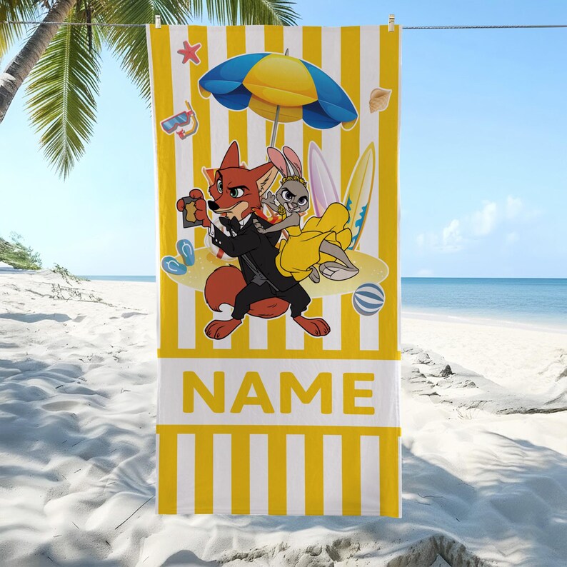 May include: Yellow and white striped beach towel featuring cartoon characters, a beach umbrella, and surfboards. The towel has the word "NAME" printed in large yellow letters on a white rectangular panel.