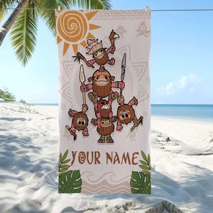 May include: A beige beach towel featuring a cartoon illustration of coconut characters in a pyramid formation, holding spears and weapons. The towel includes the text "YOUR NAME" in brown, with a sun and tropical leaf design. The towel is hanging on a clothesline on a beach.