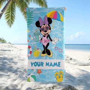 Op de afbeelding: Strandlaken met Minnie Mouse in badpak, zonnebril en strik. De achtergrond is blauw met strandthema graphics en de tekst "YOUR NAME". Inclusief een kleurrijke parasol en drankje.