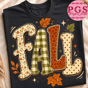 May include: A black t-shirt featuring the word FALL in large, stylized letters. Each letter has a different pattern: floral, green and white gingham, orange leopard print, and beige with brown polka dots, surrounded by orange and green leaves.