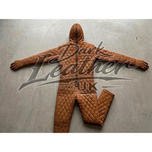 May include: A brown quilted leather jumpsuit with a hood and a full-length zipper. The jumpsuit has a diamond pattern and is spread out on a gray surface. The arms are outstretched, and the legs are slightly apart.