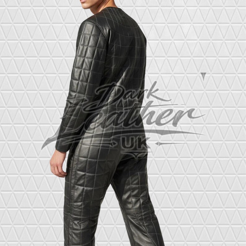 May include: A black leather jumpsuit featuring a quilted grid pattern throughout the entire garment. The long-sleeved one-piece suit has a round neckline and a fitted silhouette. The text Dark Leather UK is overlaid across the centre of the image.