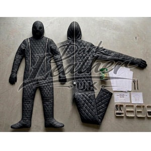 May include: Black quilted jumpsuit with a hood and full-face mask. The suit features a diamond pattern, a front zipper, and attached gloves. Additional items include patterns, small containers, and a can.