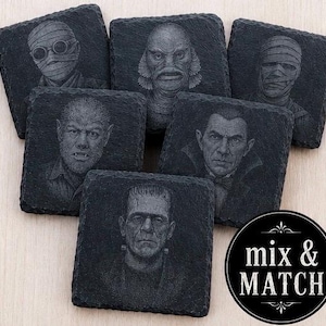 May include: A set of six square black slate coasters featuring engraved portraits of classic movie monsters including a mummy, creature from the black lagoon, werewolf, vampire, and Frankenstein's monster, with a circular black label reading mix & MATCH.