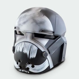 May include: A detailed, futuristic helmet in shades of gray, black, and white. The helmet features a distinctive design with a painted face and a visor. The overall aesthetic suggests a sci-fi or cosplay theme.