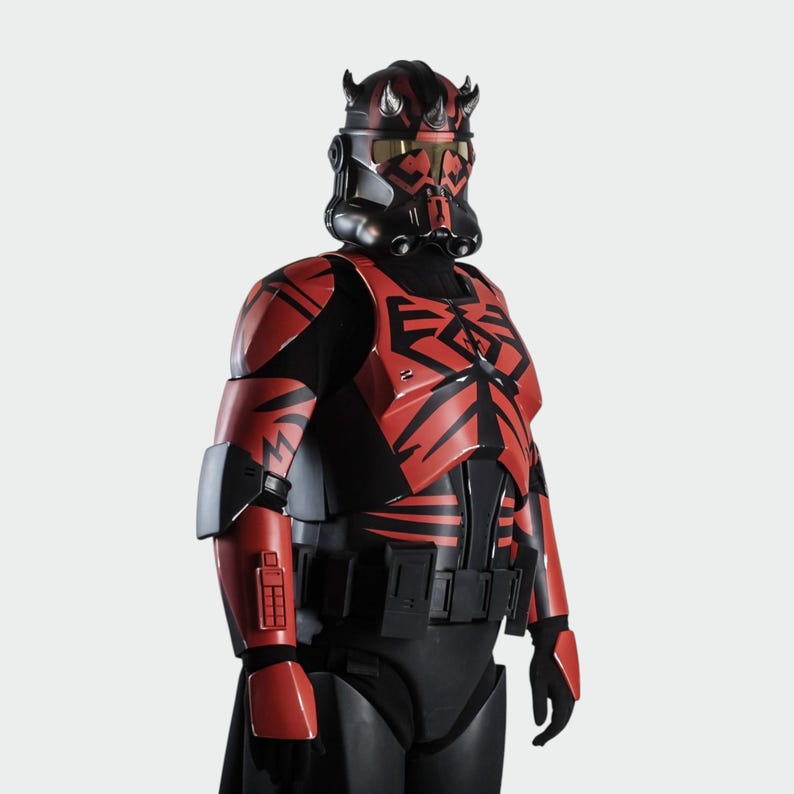May include: A red and black costume with a helmet and body armour. The helmet has horns and a visor, and the armour features geometric patterns. The costume is likely inspired by a science fiction theme, with a striking and detailed design.