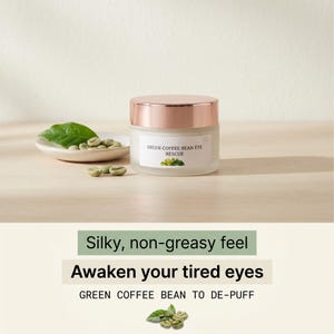 Op de afbeelding: Een pot Green Coffee Bean Eye Rescue crème met een roségouden deksel. De pot staat op een licht houten oppervlak, met groene koffiebonen en een blad op een klein wit schaaltje. De tekst op de pot luidt "Green Coffee Bean Eye Rescue".