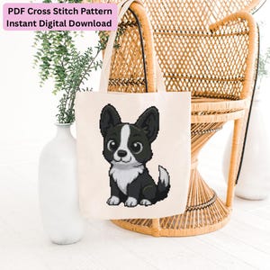 Può includere: Una borsa in tela color crema con un motivo a punto croce pixelato raffigurante un cucciolo bianco e nero con grandi occhi. Il testo in alto recita PDF Cross Stitch Pattern Instant Digital Download all'interno di un riquadro rosa.
