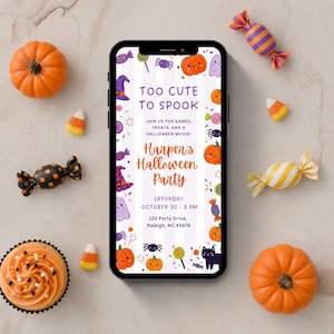 May include: A smartphone displaying a digital Halloween party invitation with the text Too Cute To Spook, Harper's Halloween Party, Saturday October 30, 3 PM, and 123 Party Drive, Raleigh, NC 45678, surrounded by pumpkins, candy, and cupcakes.