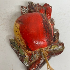 May include: A red and yellow paper mache apple with a glittery green leaf and stem. The apple is a vintage Christmas ornament.