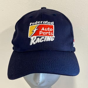 May include: A navy blue baseball cap with a white embroidered logo that says "Federated Auto Parts Racing". The logo is red, yellow, and white.