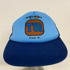 May include: Blue and navy blue trucker hat with a brown and blue logo that says "Nelson agri-center" and "Viroqua, WI."
