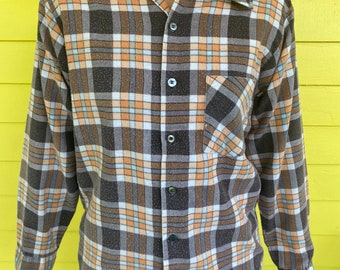 May include: A brown, orange, and white plaid long-sleeve shirt with a collared neckline and button closure.