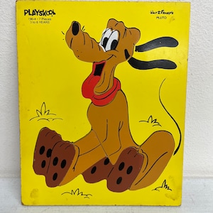 May include: A yellow wooden puzzle featuring Pluto from Disney. The puzzle is made by Playskool and is for ages 3 to 6 years old. The puzzle has 7 pieces.