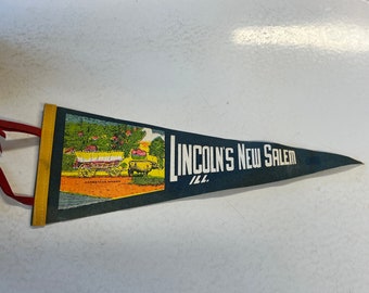May include: A blue and yellow pennant with a picture of a Conestoga wagon and the text "LINCOLN'S NEW SALEM ILL."
