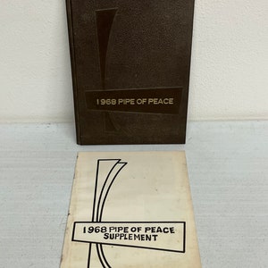 May include: A brown hardcover book with the title "1968 Pipe of Peace" on the front cover. A smaller, white paper booklet with the title "1968 Pipe of Peace Supplement" is also shown.