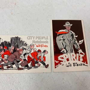 May include: Two vintage postcards featuring illustrations by Will Eisner. The first postcard shows a group of people walking down a city street. The second postcard features a comic book character called "The Spirit" in a gray suit and fedora.