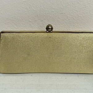 Cartera convertible en clutch vintage en tono dorado con asa plegable