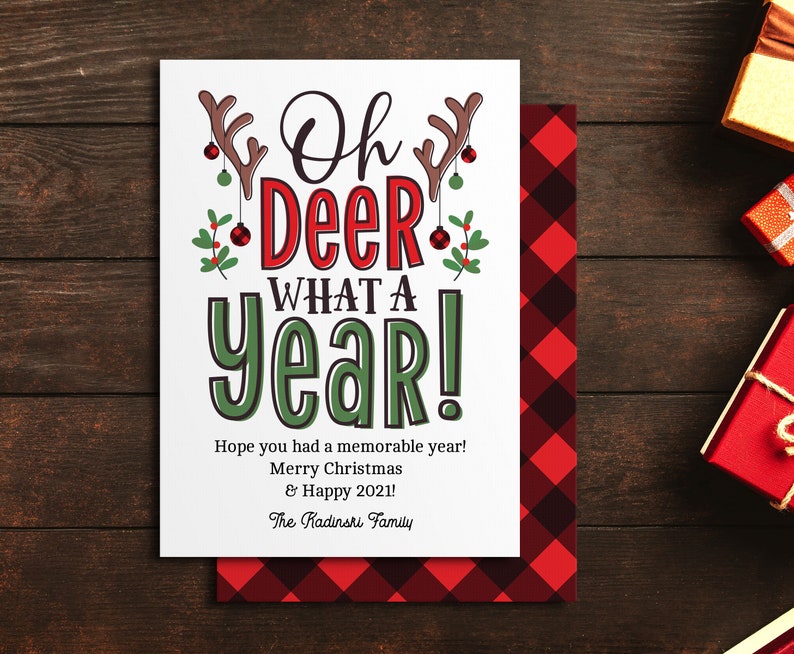 May include: A white Christmas card with a red and green illustration of a reindeer with the text "Oh Deer What A Year!" and a message wishing a memorable year, Merry Christmas and Happy 2021. The card is signed "The Kadinshi Family".