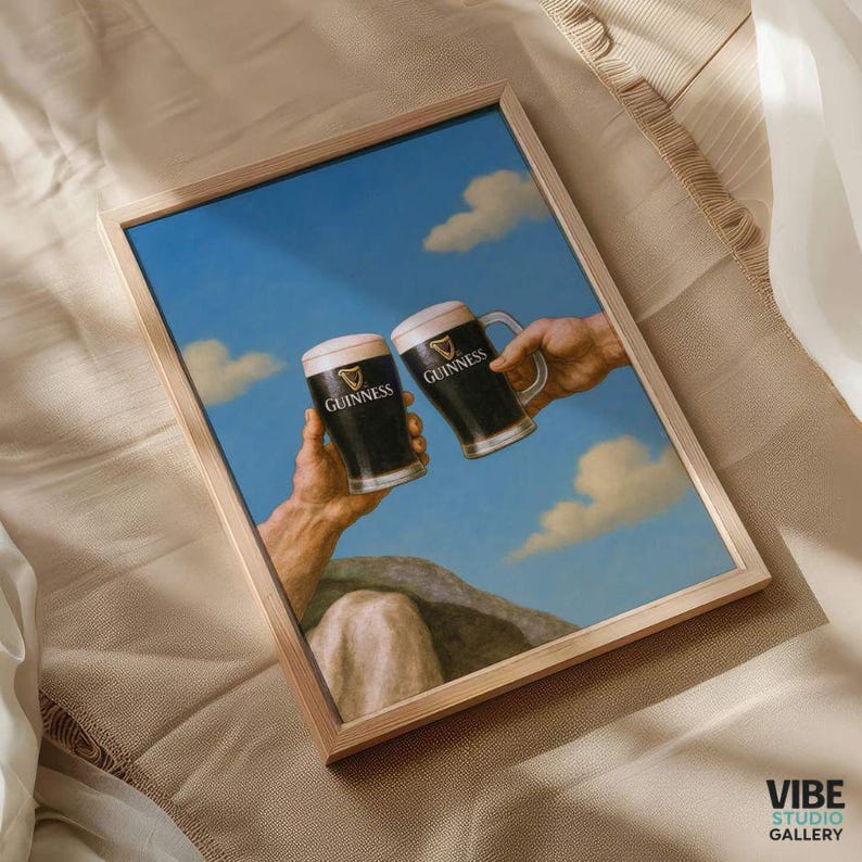 May include: Framed art print featuring two Guinness pints held aloft against a blue sky with clouds. The artwork is a parody of a classic Renaissance painting, with the Guinness logo visible on the mugs. The frame is a light wood color.