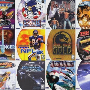 Peut inclure: Plusieurs boîtiers de jeux vidéo Sega Dreamcast, avec des titres comme "Power Stone", "NFL 2K", et "Sonic Adventure". Les jaquettes présentent des illustrations colorées et des logos de jeux. On peut aussi voir "Blue Stinger", "Mortal Kombat Gold", et "Ready 2 Rumble Boxing".