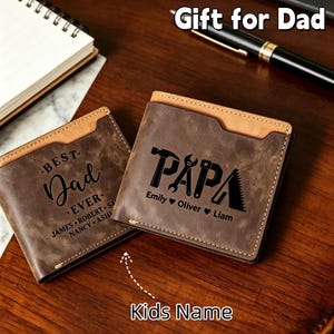 May include: Two brown leather wallets with tan accents. One wallet reads "BEST Dad EVER" with names below. The other wallet says "PAPA" with tools and children's names. The text "Gift for Dad" is at the top.