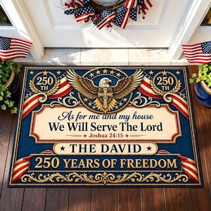 May include: A blue doormat with patriotic design. It features an eagle with a cross, the text "As for me and my house We Will Serve The Lord," and "250 YEARS OF FREEDOM." The mat is decorated with American flags.