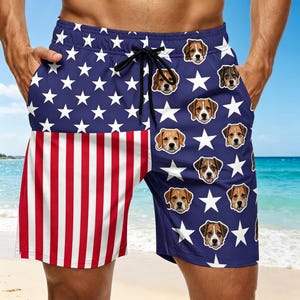 May include: Navy blue swim trunks featuring the American flag design on the left leg and a pattern of white stars and dog faces on the right leg. The shorts have a drawstring closure and pockets.
