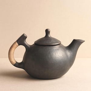 Tetera de cerámica negra Longpi: tetera artesanal de arcilla serpentinita con asa de caña, decoración rústica bohemia para cocina, vajilla funcional.