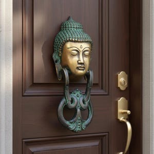 以下が含まれることがあります： 髪の部分に緑青色の緑色の緑青が施され、顔の部分に磨かれた真鍮仕上げが施された、仏頭の形をした金属製のドアノッカー。ノッカーには、あごの下に取り付けられた円形の装飾的なスイングリングが付いており、木製のドアに取り付けられています。