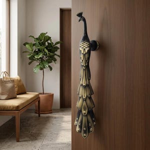Peut inclure: Une poignée de porte décorative en forme de paon. La poignée est noire et dorée, avec des détails complexes sur les plumes. Elle est fixée sur une porte en bois.