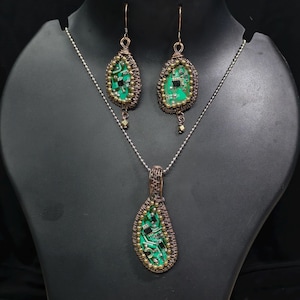 May include: A unique jewelry set featuring a pendant necklace and matching earrings. Each piece showcases a green circuit board design encased in copper wire. The earrings hang from copper hooks, and the necklace has a silver chain.