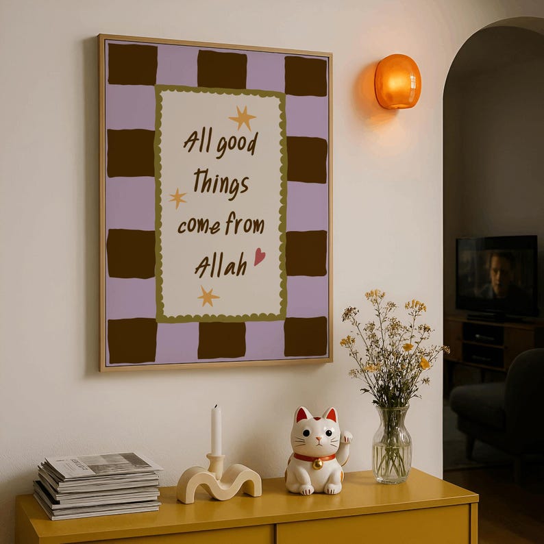 May include: A framed wall art print featuring a light purple and dark brown checkered border surrounding a cream-colored center with the text All good things come from Allah, accented by small yellow stars and a pink heart graphic.