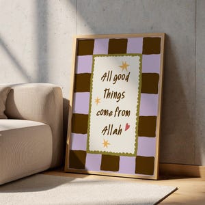 May include: A rectangular framed wall art print featuring a brown and light purple checkered border. The central cream-colored panel has a scalloped olive green edge, brown text reading All good things come from Allah, three yellow stars, and a small red heart.