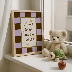 May include: A framed print featuring a light purple and dark brown checkered background with a central cream-colored rectangle containing the text "All good things come from Allah" in dark brown, accented by small yellow stars and a red heart.
